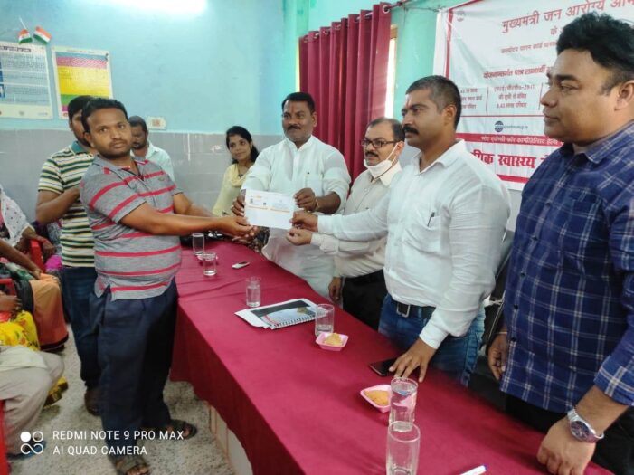 जन आरोग्य मेले मे लाभार्थी को कार्ड वितरित करते ब्लॉक प्रमुख व अन्य