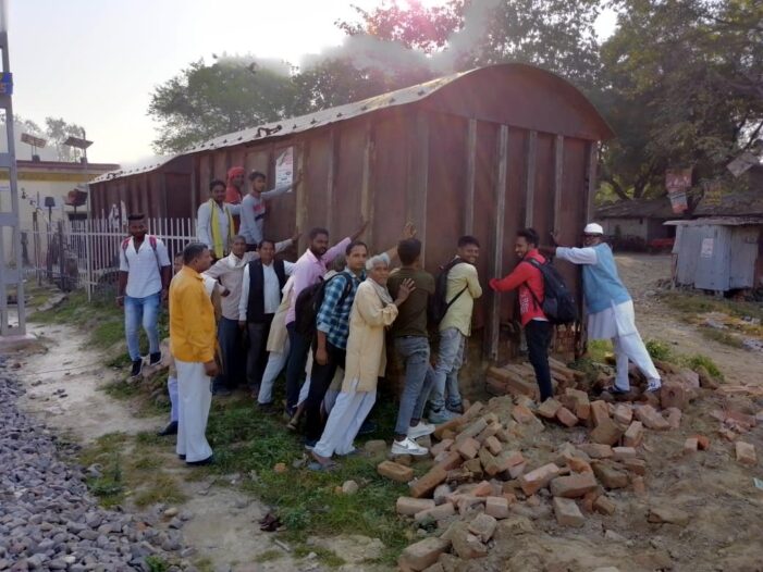 प्रदर्षन में डिब्बे को गिराने का प्रयास करते रेलयात्री प्रदर्षन में डिब्बे को गिराने का प्रयास करते रेलयात्री