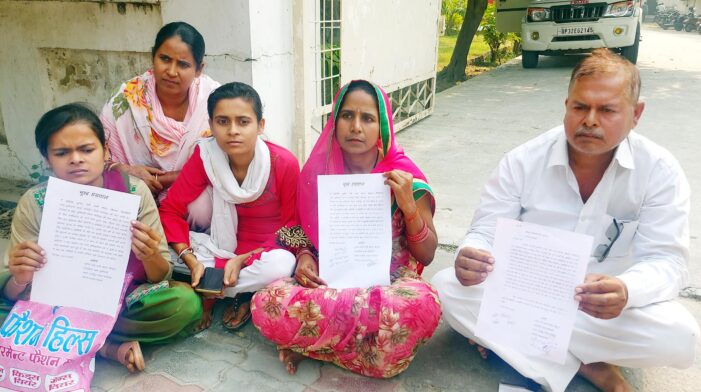 परिवार संग भूख हड़ताल पर बैठी महिला प्रधान परिवार संग भूख हड़ताल पर बैठी महिला प्रधान